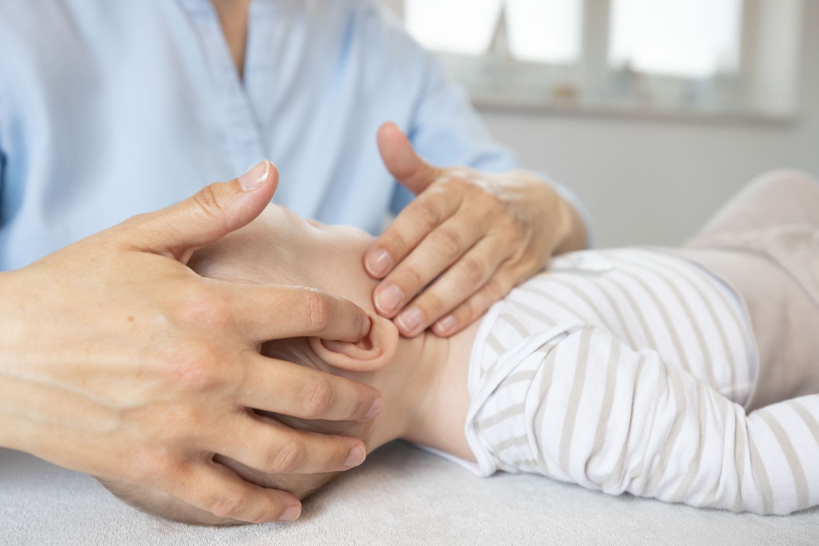 Behutsame Behandlung an Arm und Hand eines Babys
