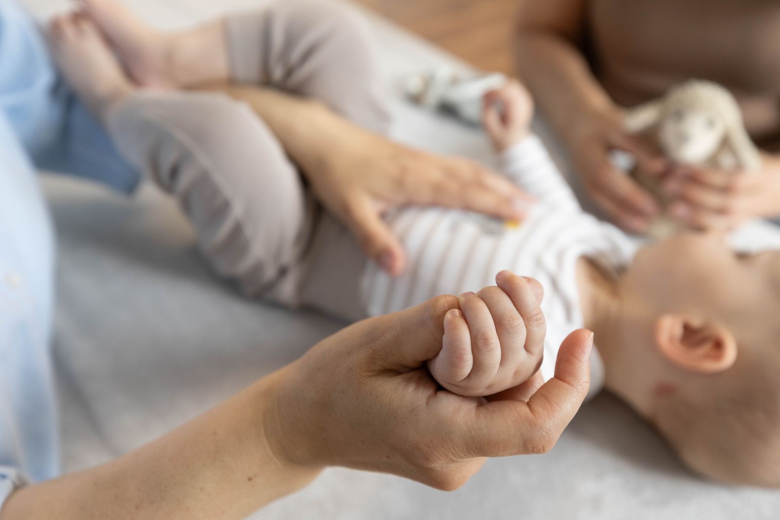 Die Hand eines Säuglings umgreift einen Finger